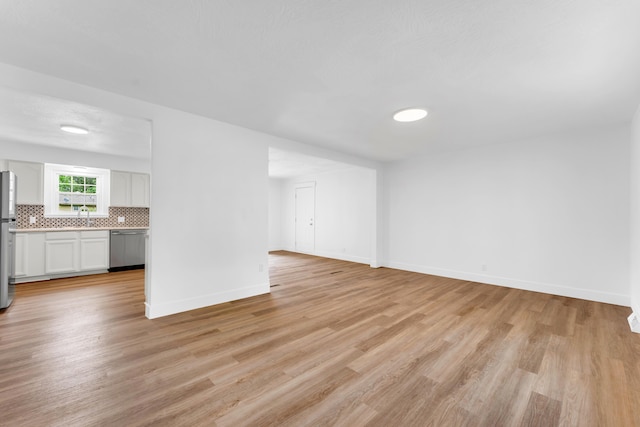 1107 E Mccracken Rd, Ozark, MO 65721 - unfurnished living room featuring light wood-style flooring and baseboards