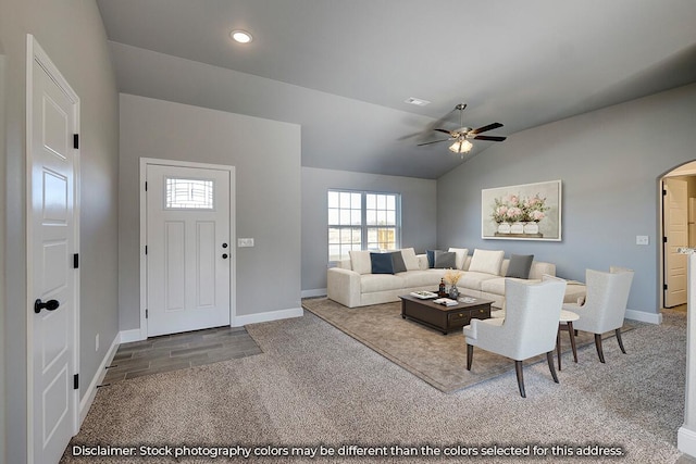 living area with ceiling fan, arched walkways, baseboards, lofted ceiling, and carpet