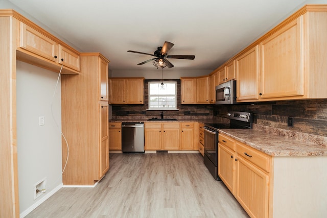 kitchen with a sink, light brown cabinetry, stainless steel appliances, and light wood-type flooring