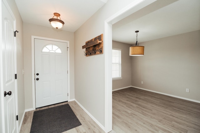 entrance foyer with light wood-type flooring, baseboards, and a wealth of natural light