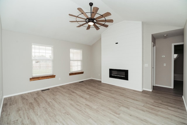 unfurnished living room with a fireplace, a ceiling fan, wood finished floors, vaulted ceiling, and visible vents