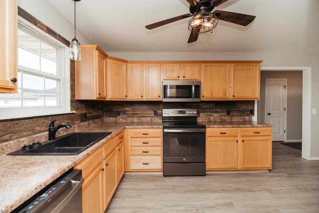 kitchen with a sink, light brown cabinetry, tasteful backsplash, and stainless steel appliances