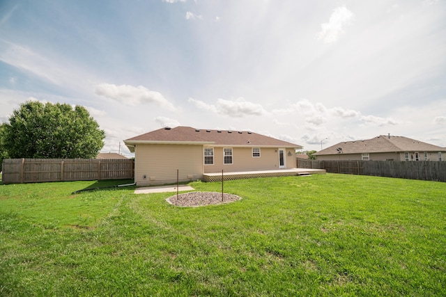 rear view of property with a yard, a deck, and a fenced backyard