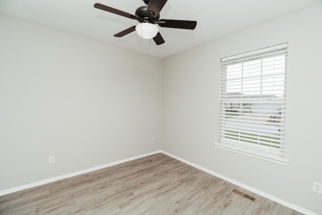 spare room featuring baseboards, a ceiling fan, wood finished floors, and visible vents
