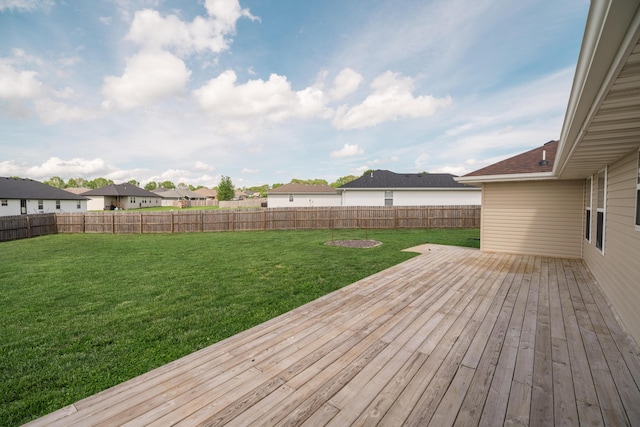 wooden terrace with a fenced backyard, a lawn, and a residential view