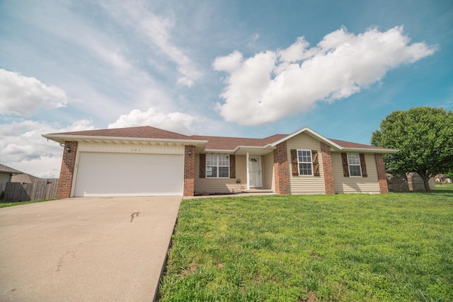 ranch-style house featuring an attached garage, a front yard, driveway, and brick siding