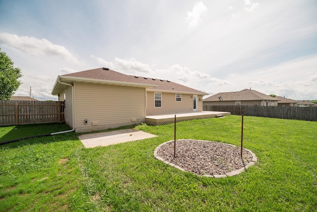 rear view of property with a lawn, a patio, and a fenced backyard