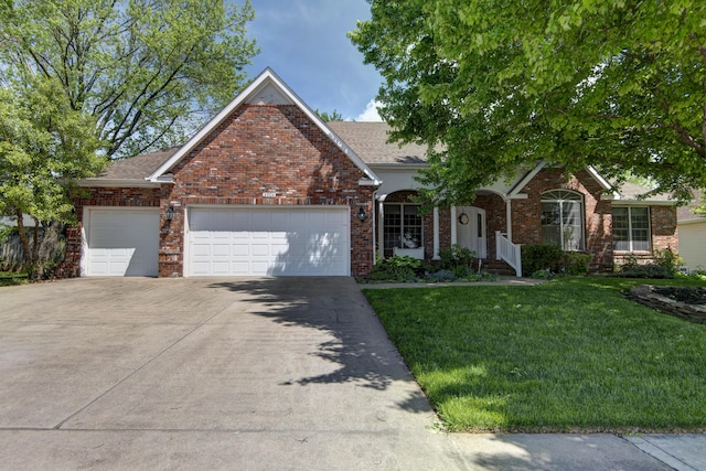 view of front of house with brick siding, an attached garage, driveway, and a front yard