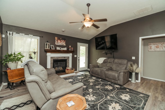 living room with ceiling fan, lofted ceiling, wood finished floors, and visible vents