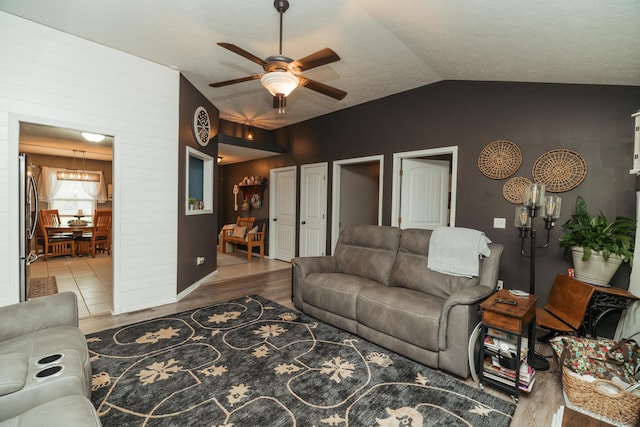 living area featuring ceiling fan, vaulted ceiling, and wood finished floors