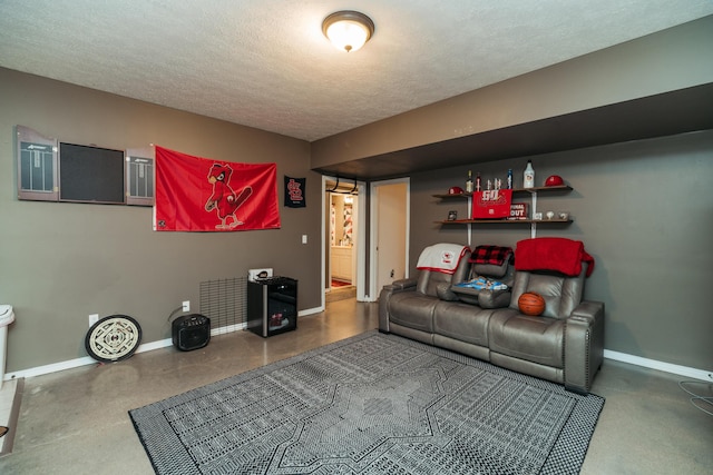 living room with a textured ceiling, baseboards, and concrete floors