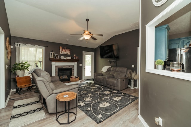 living area featuring light wood-type flooring, ceiling fan, and vaulted ceiling