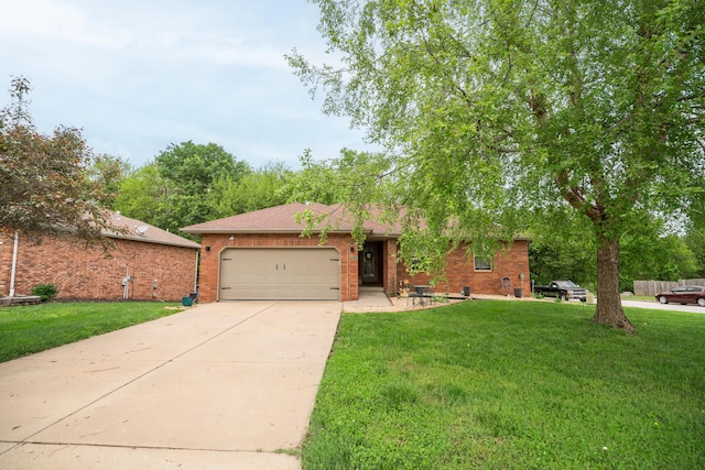 ranch-style house featuring an attached garage, concrete driveway, brick siding, and a front yard