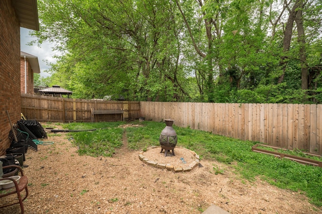 view of yard featuring a fire pit and a fenced backyard