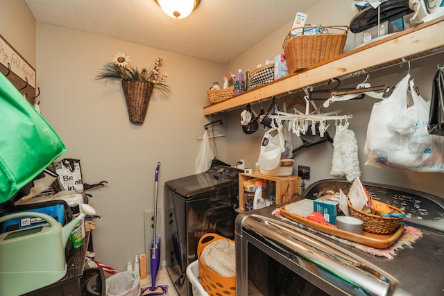 laundry room featuring a textured ceiling, laundry area, and washer and clothes dryer