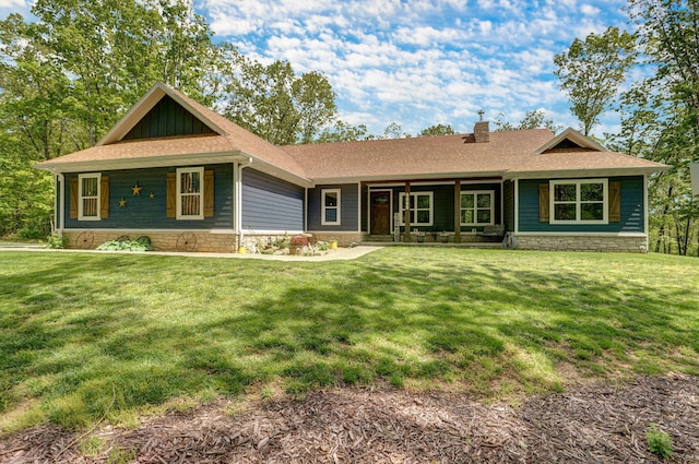 view of front of property featuring covered porch, a front yard, a chimney, and roof with shingles