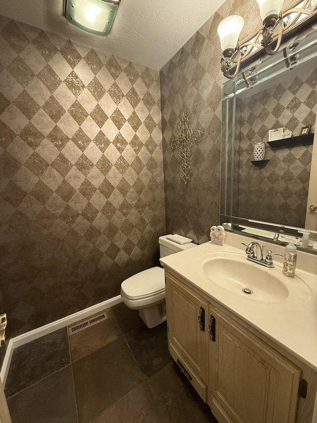 bathroom featuring toilet, tile patterned floors, visible vents, and vanity