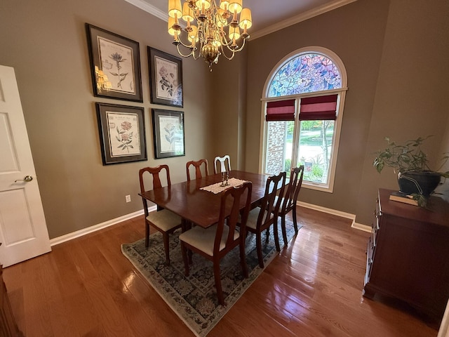 dining room featuring ornamental molding, baseboards, a notable chandelier, and wood finished floors