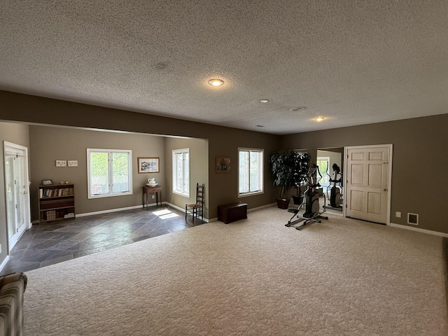 exercise area with carpet flooring, a textured ceiling, visible vents, baseboards, and recessed lighting