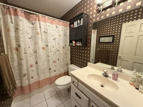 full bath with toilet, vanity, a textured ceiling, tile patterned floors, and wallpapered walls