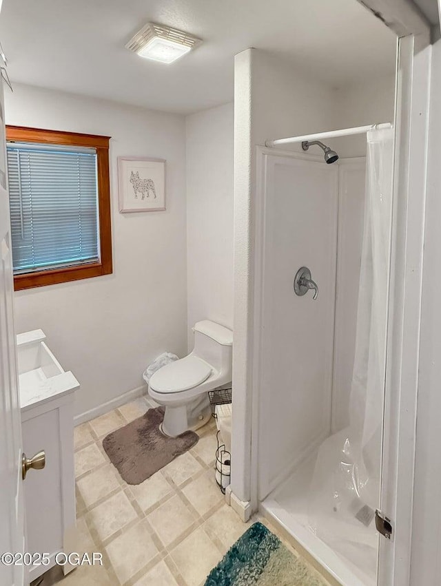 bathroom featuring vanity, toilet, and a shower stall