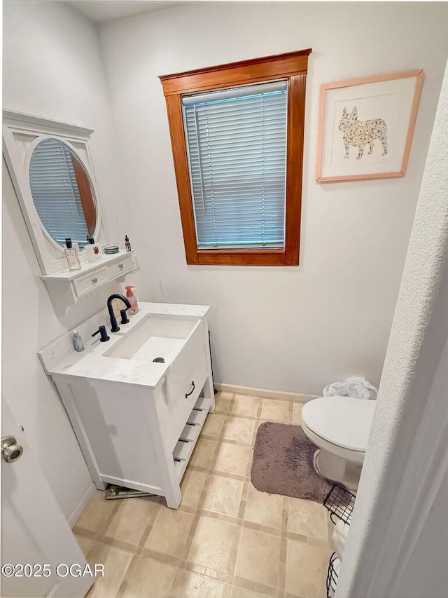 bathroom with vanity, baseboards, and toilet