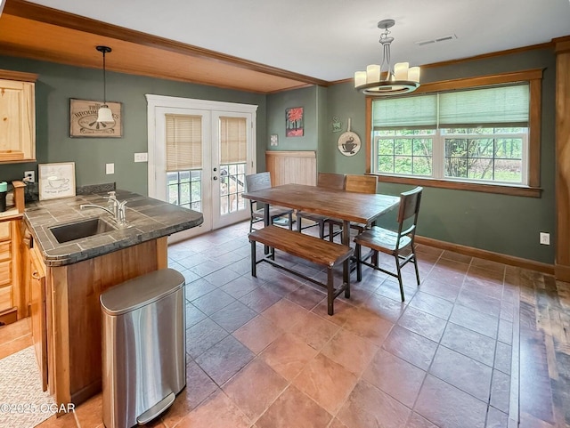 dining area with plenty of natural light, a notable chandelier, visible vents, and french doors