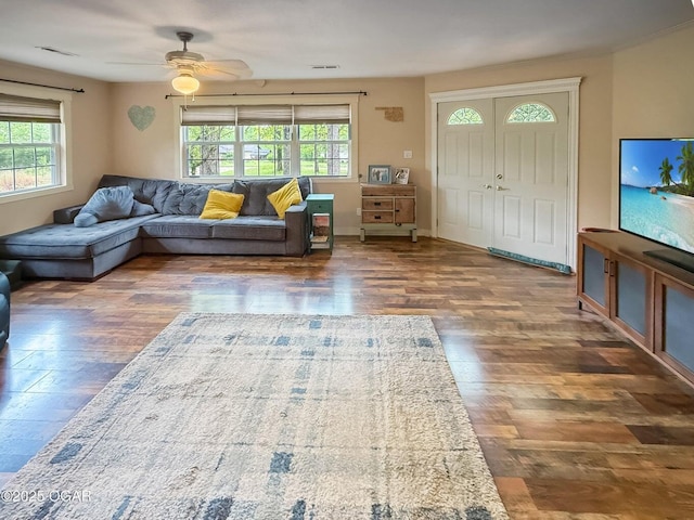 living area featuring ceiling fan, visible vents, and wood finished floors
