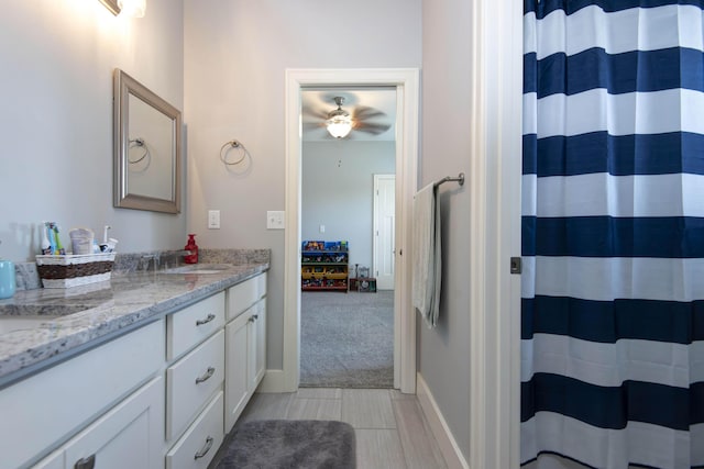full bath featuring vanity, baseboards, ceiling fan, and curtained shower