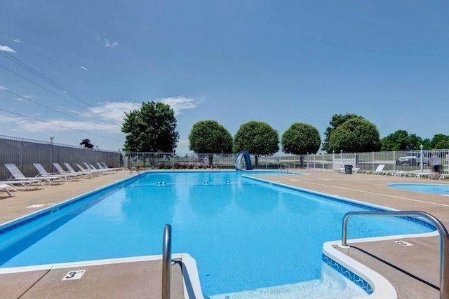 community pool featuring fence and a patio area