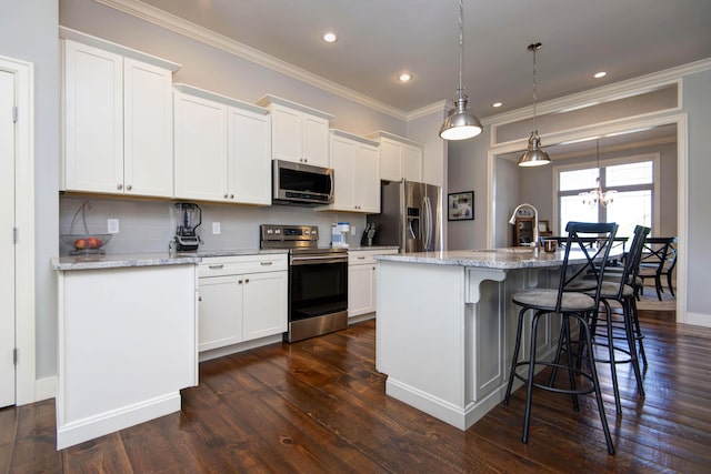 kitchen with a breakfast bar area, crown molding, appliances with stainless steel finishes, a sink, and dark wood-style floors