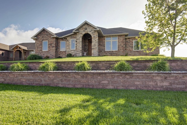 ranch-style house with brick siding, roof with shingles, and a front lawn