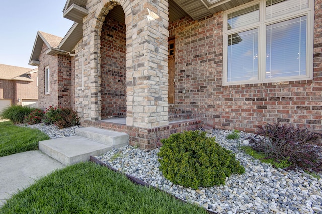 view of exterior entry featuring brick siding
