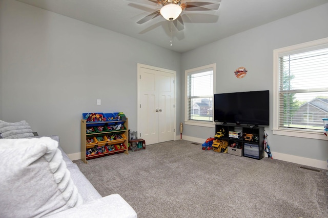 interior space featuring a healthy amount of sunlight, a ceiling fan, and carpet flooring