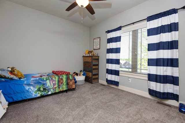 carpeted bedroom with baseboards, a ceiling fan, and visible vents