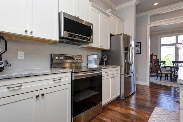 kitchen with crown molding, dark wood-style floors, white cabinets, tasteful backsplash, and stainless steel appliances