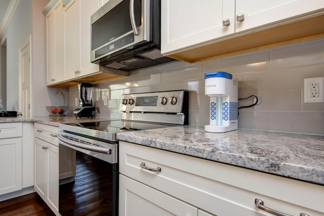 kitchen with white cabinets, light stone counters, dark wood finished floors, backsplash, and stainless steel appliances