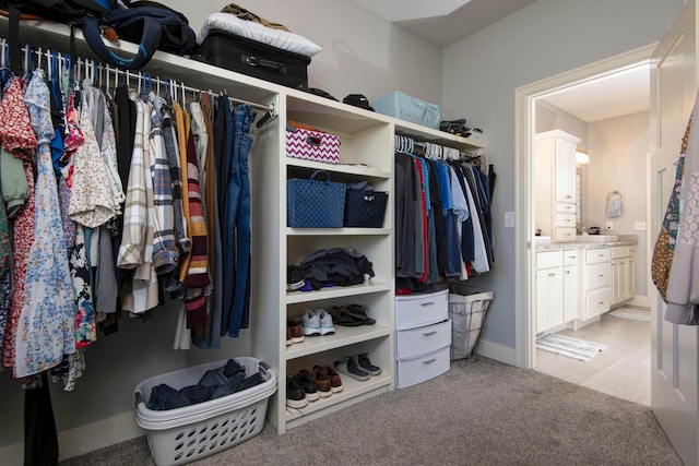 walk in closet featuring light carpet