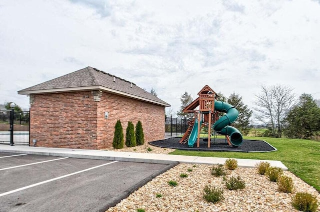 community play area featuring a lawn and fence