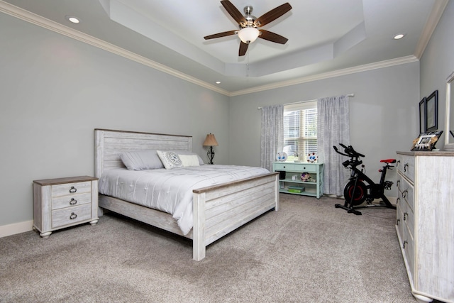 carpeted bedroom featuring ornamental molding, a tray ceiling, and recessed lighting