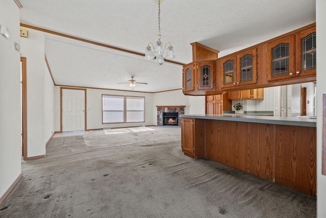 26929 Cordwood Ridge Dr, Shell Knob, MO 65747 - kitchen featuring glass insert cabinets, a stone fireplace, brown cabinets, carpet, and ceiling fan with notable chandelier