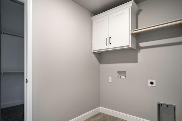 clothes washing area with cabinet space, hookup for a washing machine, baseboards, electric dryer hookup, and wood finished floors