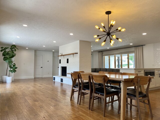 1908 Timber Ln, West Plains, MO 65775 - dining area with a brick fireplace, recessed lighting, a chandelier, and light wood-type flooring