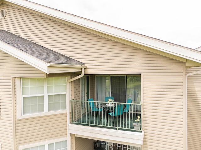 view of side of home featuring roof with shingles