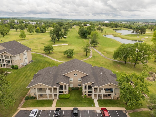 birds eye view of property with view of golf course and a water view