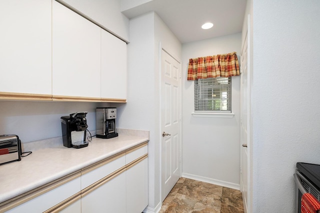 interior space featuring baseboards, stone finish floor, and a toaster