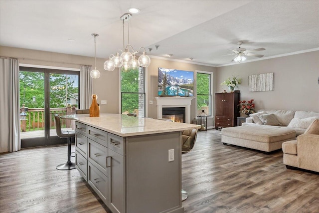 kitchen featuring a center island, a kitchen breakfast bar, gray cabinets, and open floor plan