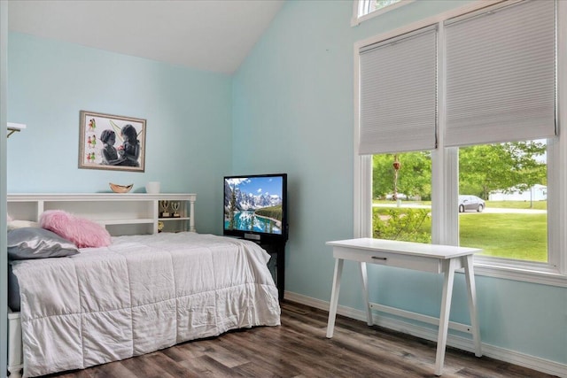 bedroom featuring baseboards, wood finished floors, and lofted ceiling