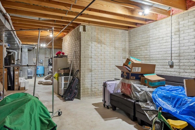 unfinished basement with brick wall and heating unit