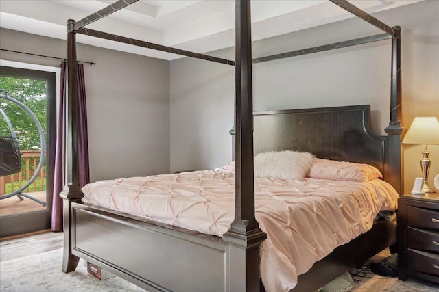 bedroom with access to outside and wood finished floors